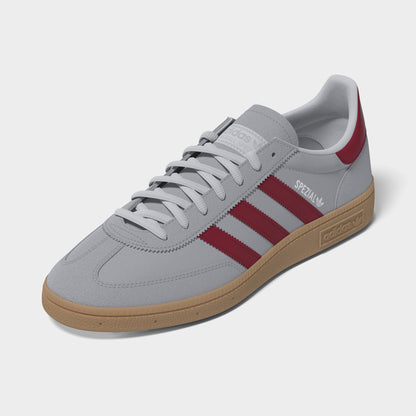 adidas Handball Spezial. Three-quarter view of halo silver, team victory red and gum sneakers with grey laces, red stripes and gum soles.