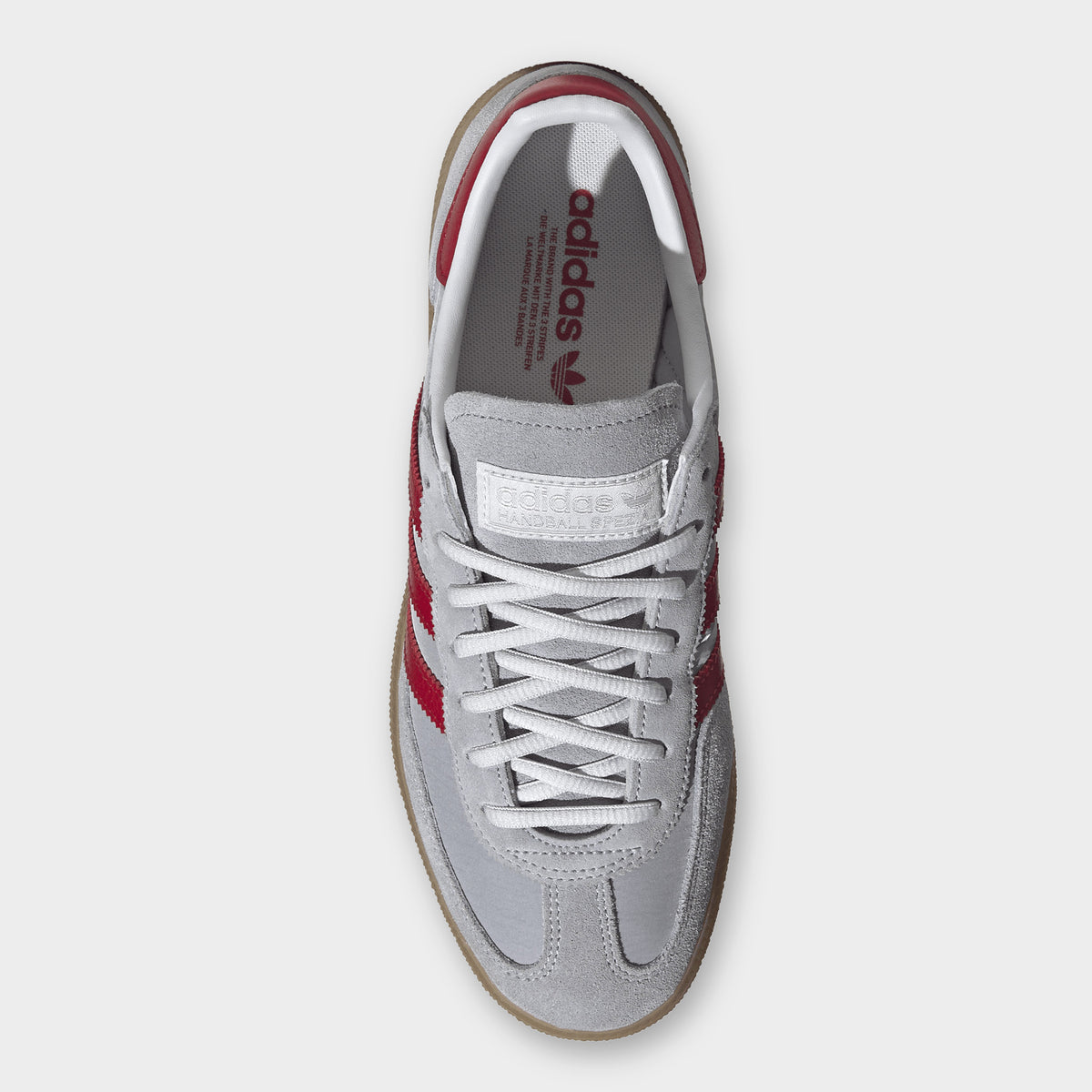 adidas Handball Spezial. Top view of halo silver, team victory red and gum sneaker showing grey laces, padded tongue and red collar lining.