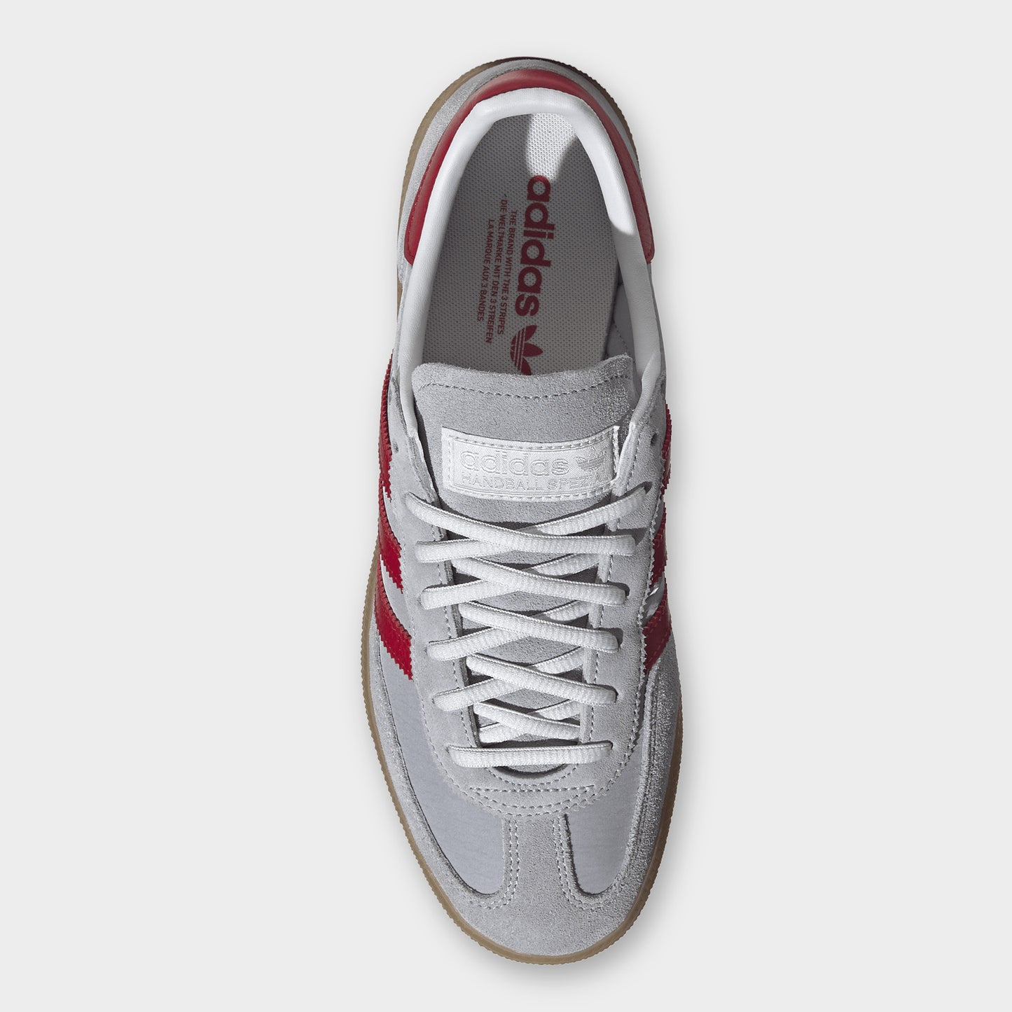 adidas Handball Spezial. Top view of halo silver, team victory red and gum sneaker showing grey laces, padded tongue and red collar lining.