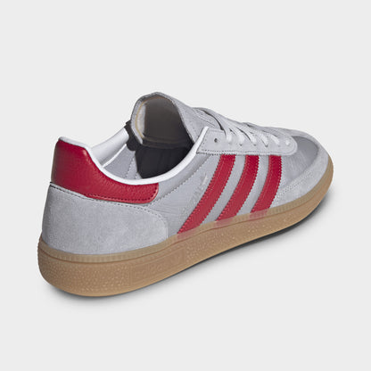 adidas Handball Spezial. Rear three-quarter view of halo silver, team victory red and gum sneakers with red heel tabs and gum soles.