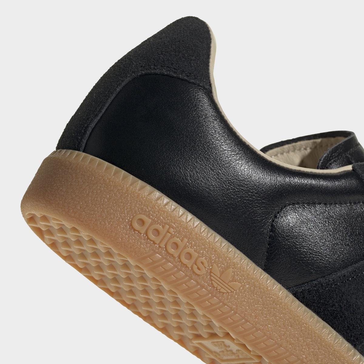 adidas BW Army. Close-up of black and gum sneaker showing black heel panel, padded collar and textured gum outsole edge.