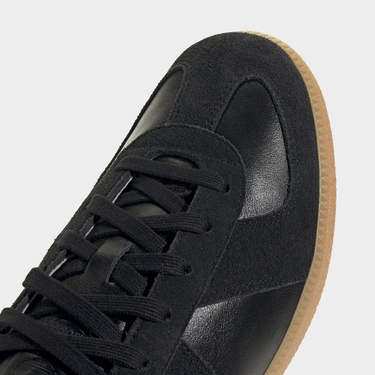 adidas BW Army. Close-up of black and gum sneaker showing black laces, tonal three stripes and stitched toe panel.