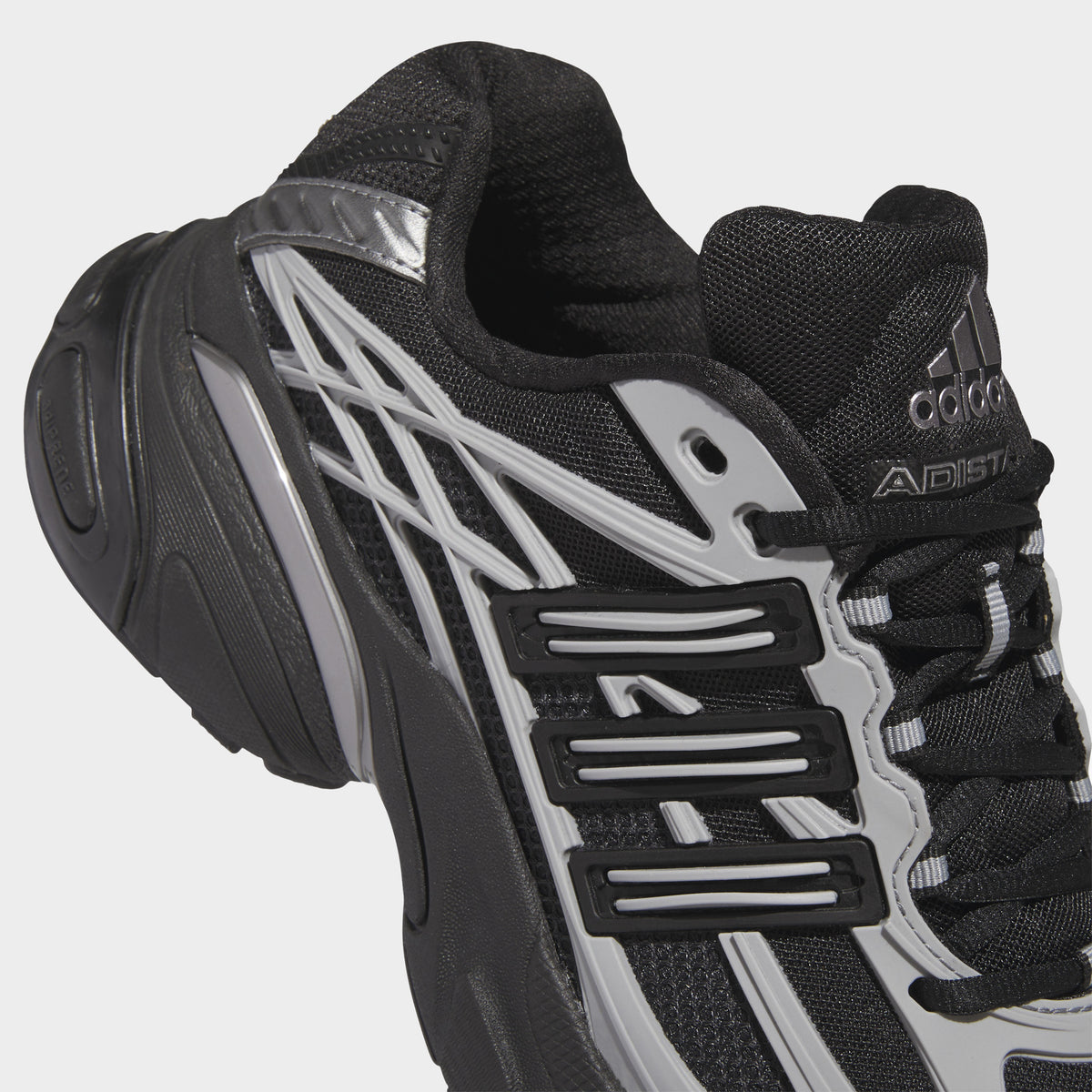 adidas Adistar XLG 2.0. Close-up of core black and iron metallic sneaker showing black laces, mesh panels, tongue branding and metallic three stripes.