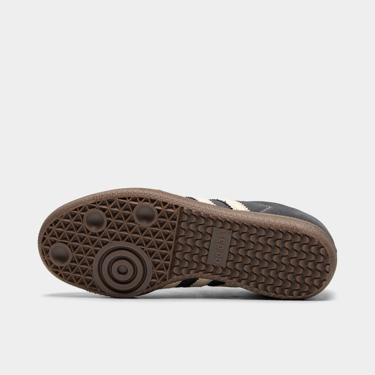adidas Juniors' Samba OG. Bottom view of single shoe displaying full gum rubber outsole with classic Samba tread pattern, suction cup pivot points, and center adidas logo. 