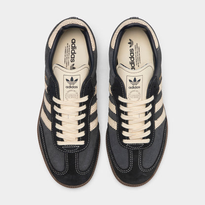 adidas Juniors' Samba OG. Top-down overhead view of a pair of low-top sneakers displaying carbon dark grey suede T-toe overlays, carbon suede uppers, warm vanilla laces, warm vanilla leather tongues with dark Trefoil logos, and off-white insoles with dark grey adidas Trefoil branding. 