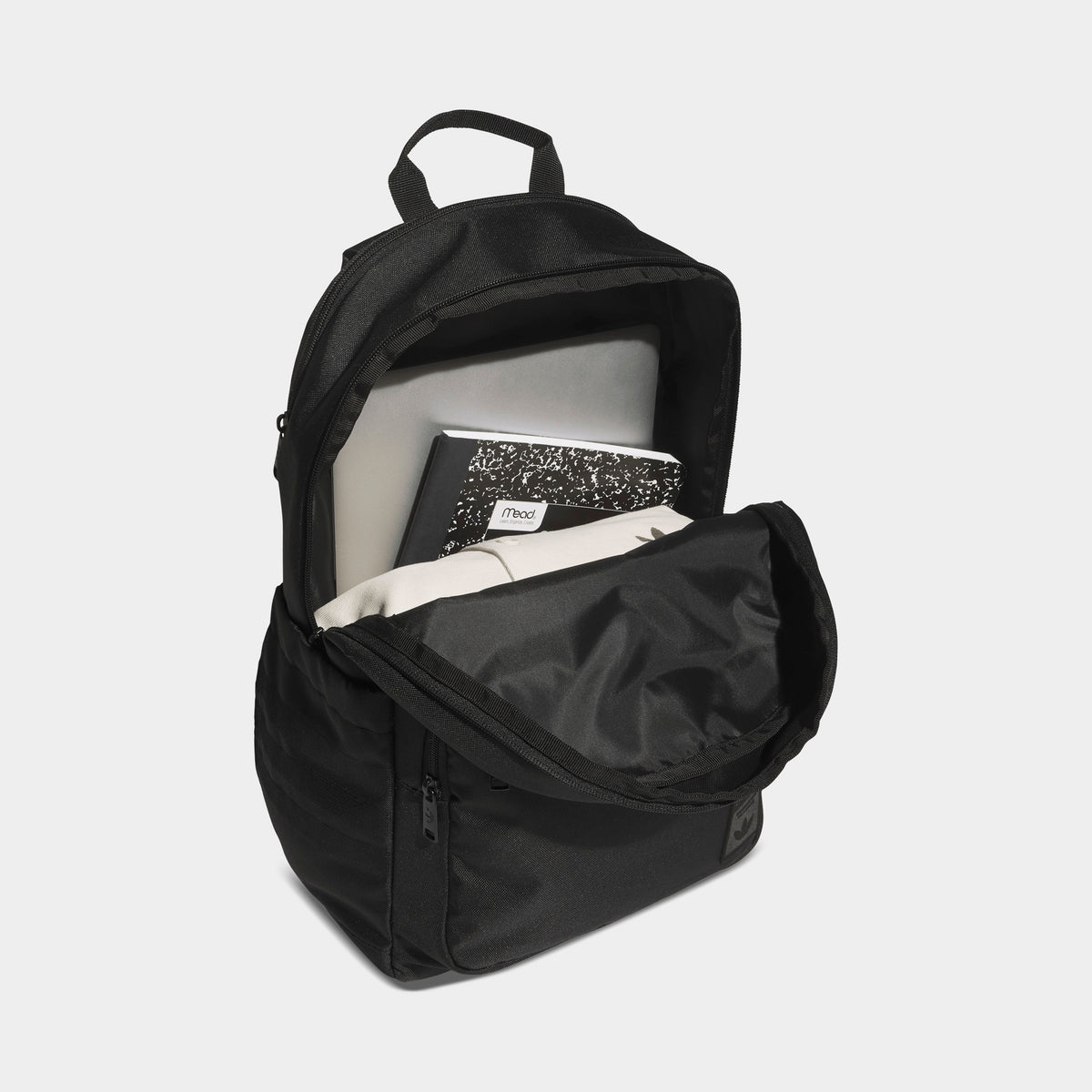 adidas Premise 2.0 Backpack. Interior view of black backpack showing the open main compartment, internal sleeve and zippered front section.