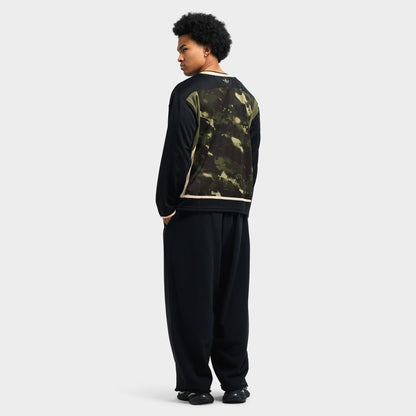 adidas Hockey Jersey. Full-length front view of model wearing gothic olive strata camo jersey styled with baggy black pants. 