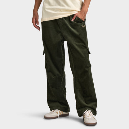 adidas Adicolor Cord Cargo Pants. Front view of model wearing night cargo corduroy pants with wide legs, elastic waistband and large side cargo pockets.