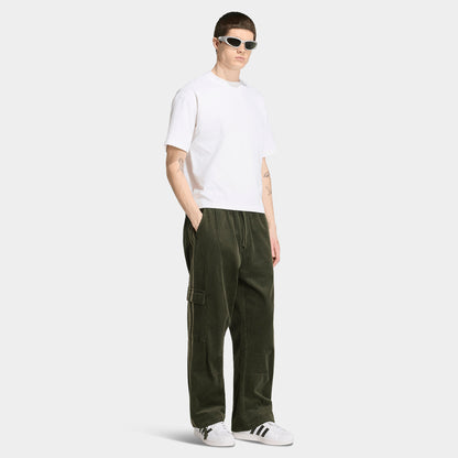 adidas Adicolor Cord Cargo Pants. Full-body view of model wearing night cargo corduroy pants with wide legs and large side pockets.