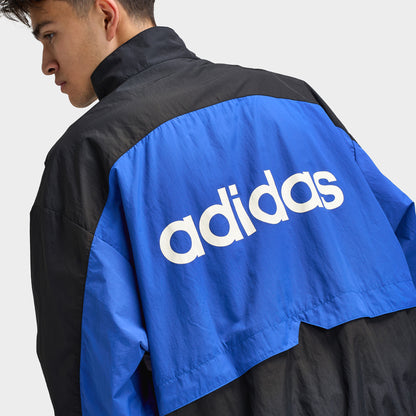 adidas Munich 93 Tracktop. Close-up of blue and black track jacket showing large white adidas logo across the back panel.