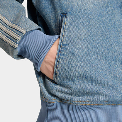 adidas Firebird Adicolor Track Top. Close-up of worn blue denim track jacket showing side pocket, contrast stitching and striped sleeve.