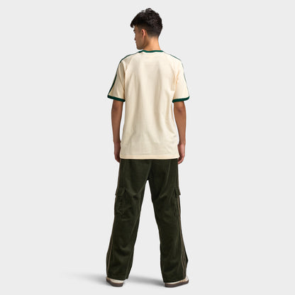 adidas 3 Stripes T-Shirt. Full-body back view of model wearing vanilla and collegiate green T-shirt with dark green pants and light-coloured shoes.
