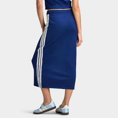 adidas 3 Stripe Knitted Skirt. Lower body three-quarter rear model view showing the smooth back profile of the dark blue knitted midi skirt, contrast white 3-Stripes side taping, and straight midi-length cut. 