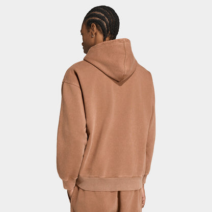 adidas Trefoil Essentials Washed Loose Hoodie. Back view of model wearing preloved brown hoodie with raised hood and loose silhouette.