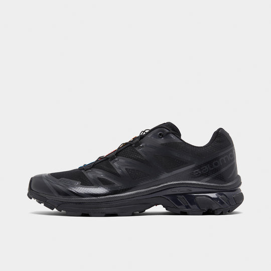Salomon XT-6. Side view of black and phantom trail sneaker with layered overlays, tonal Salomon branding and lugged outsole.