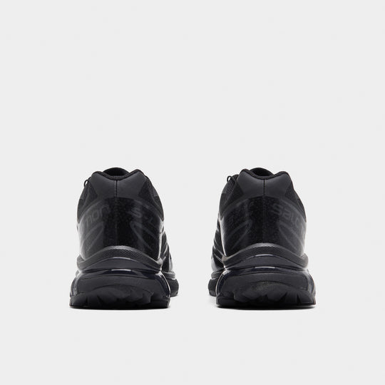 Salomon XT-6. Rear view of black and phantom trail sneakers with padded heel panels, pull tabs and lugged outsoles.
