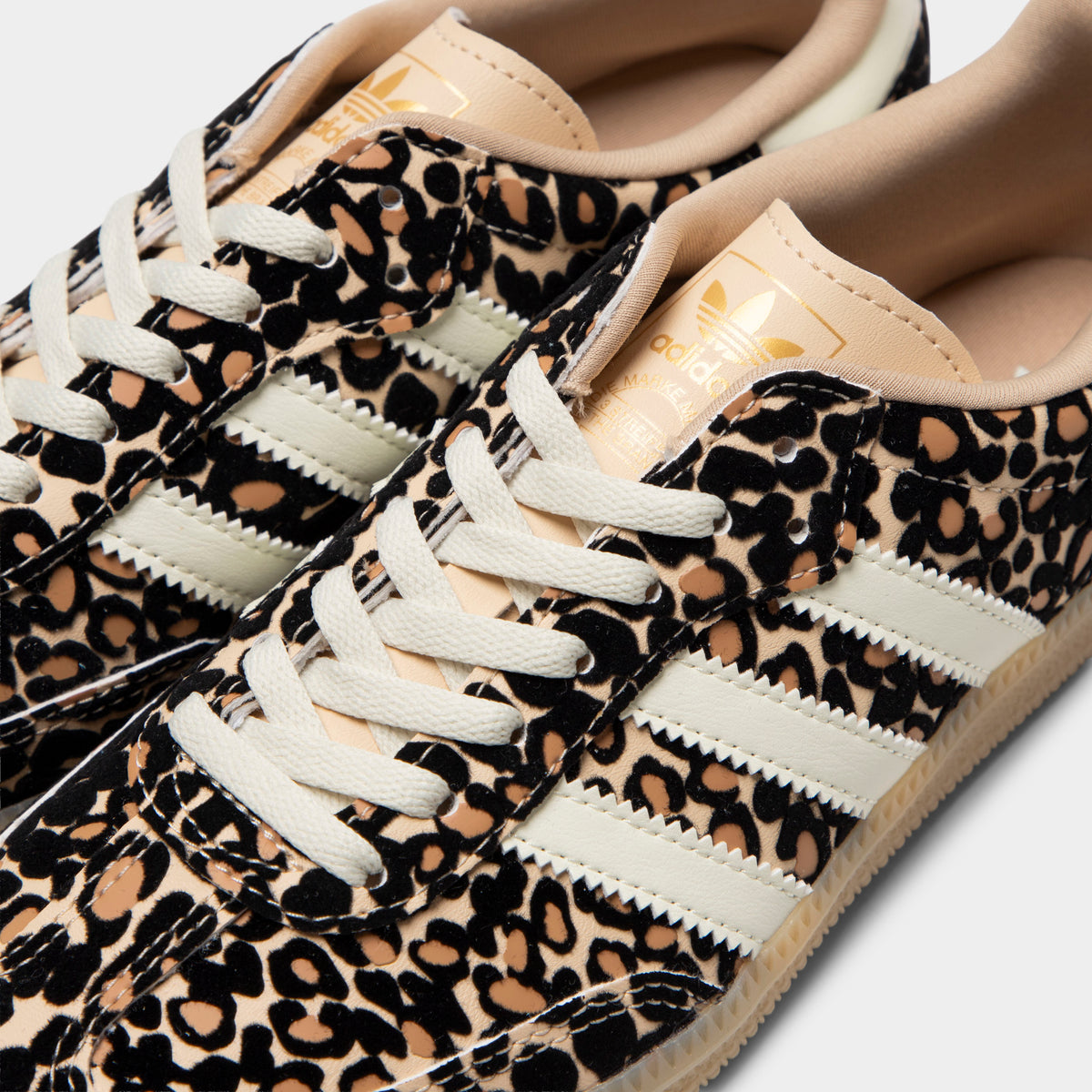 adidas Juniors' Samba OG J. Close-up of sand strata, ivory and gum junior sneaker showing white laces, leopard-print upper and ivory three stripes.