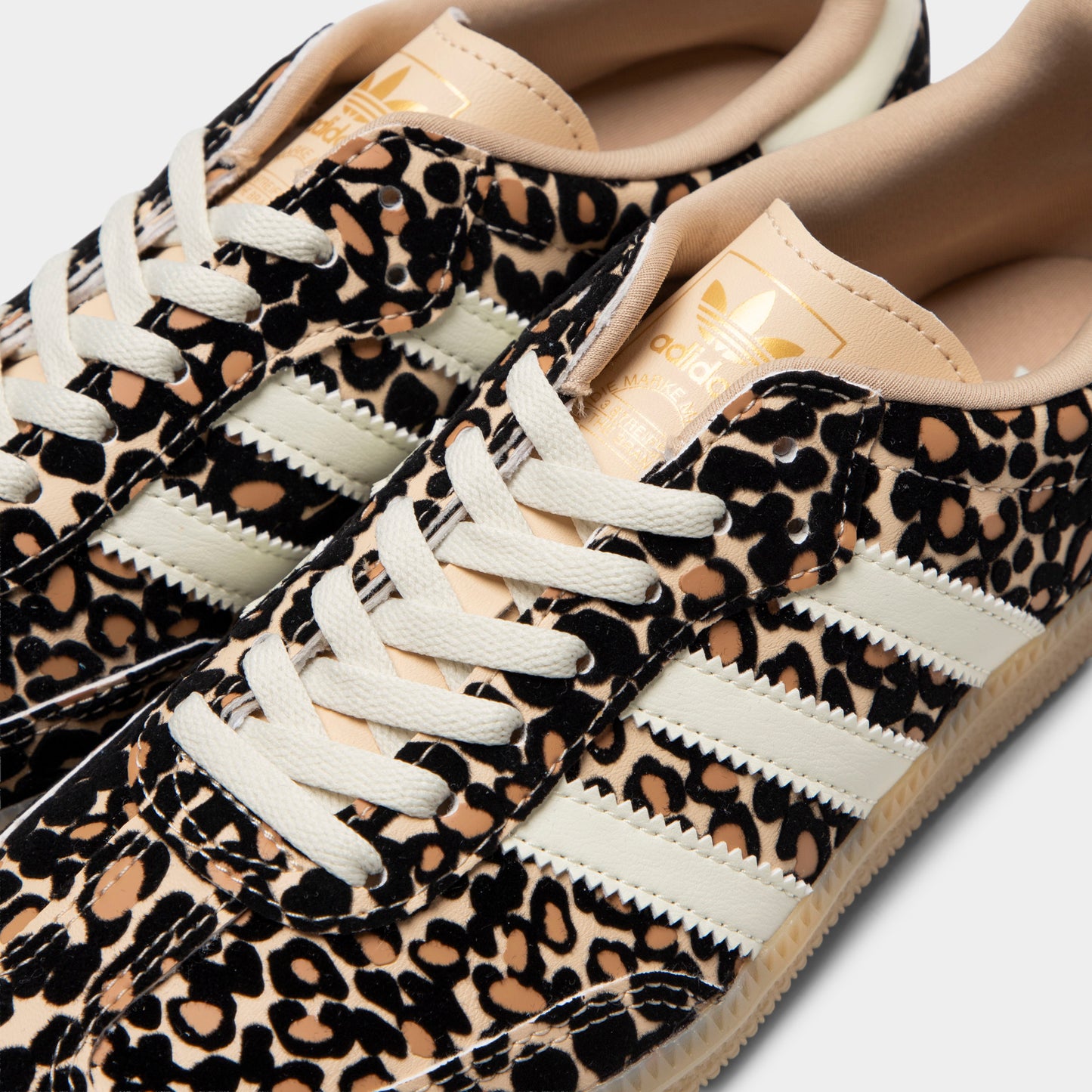 adidas Juniors' Samba OG J. Close-up of sand strata, ivory and gum junior sneaker showing white laces, leopard-print upper and ivory three stripes.