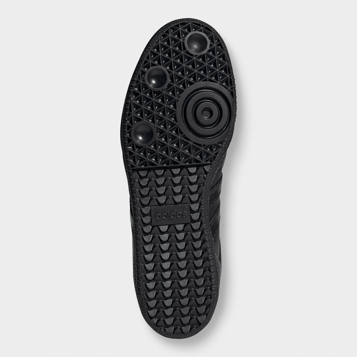 adidas Samba OG. Bottom view of black sneaker showing black outsole with circular forefoot tread and herringbone grooves.
