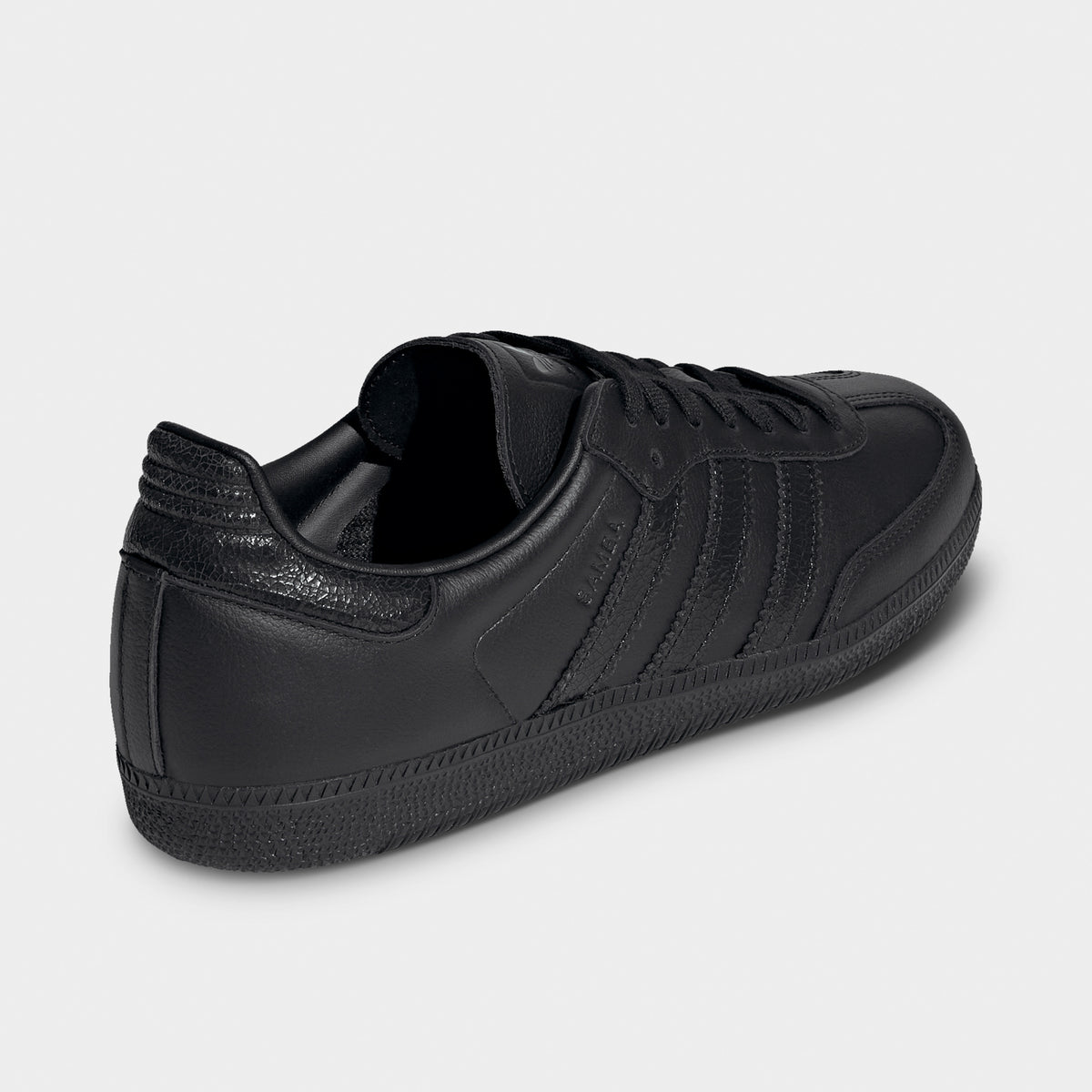 adidas Samba OG. Opposite side view of black sneaker with layered panels, tonal heel tab and black sole.