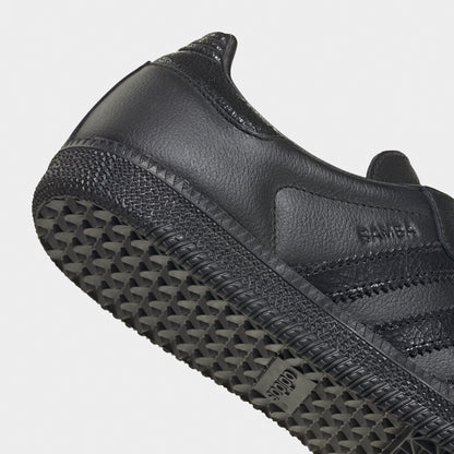 adidas Samba OG. Close-up of black sneaker showing tonal heel panel, side branding and textured outsole edge.