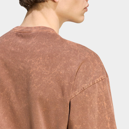 adidas Trefoil Essential Washed Loose T-Shirt. Close-up of preloved brown T-shirt showing washed texture, crew neckline and relaxed shoulder seams.