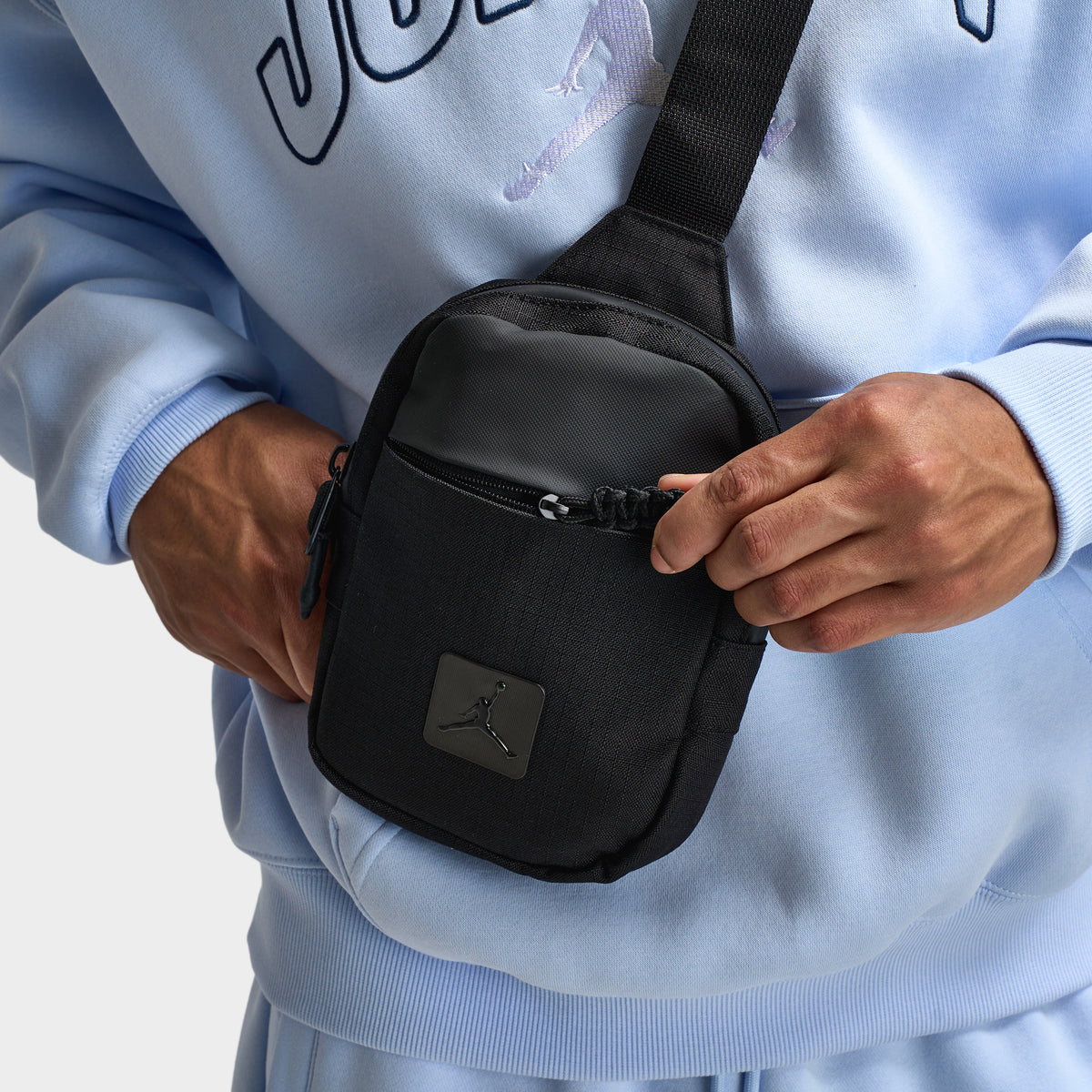 Jordan Franchise Hip Bag. Close-up of black hip bag showing zippered front compartment, adjustable strap and tonal Jordan logo patch.