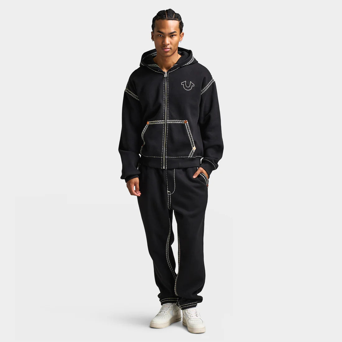 Man wears True Religion Super Quad Stitch Zip‑Up Hoodie “Black” hoodie. Shop Men’s Clothing now at JD Sports.