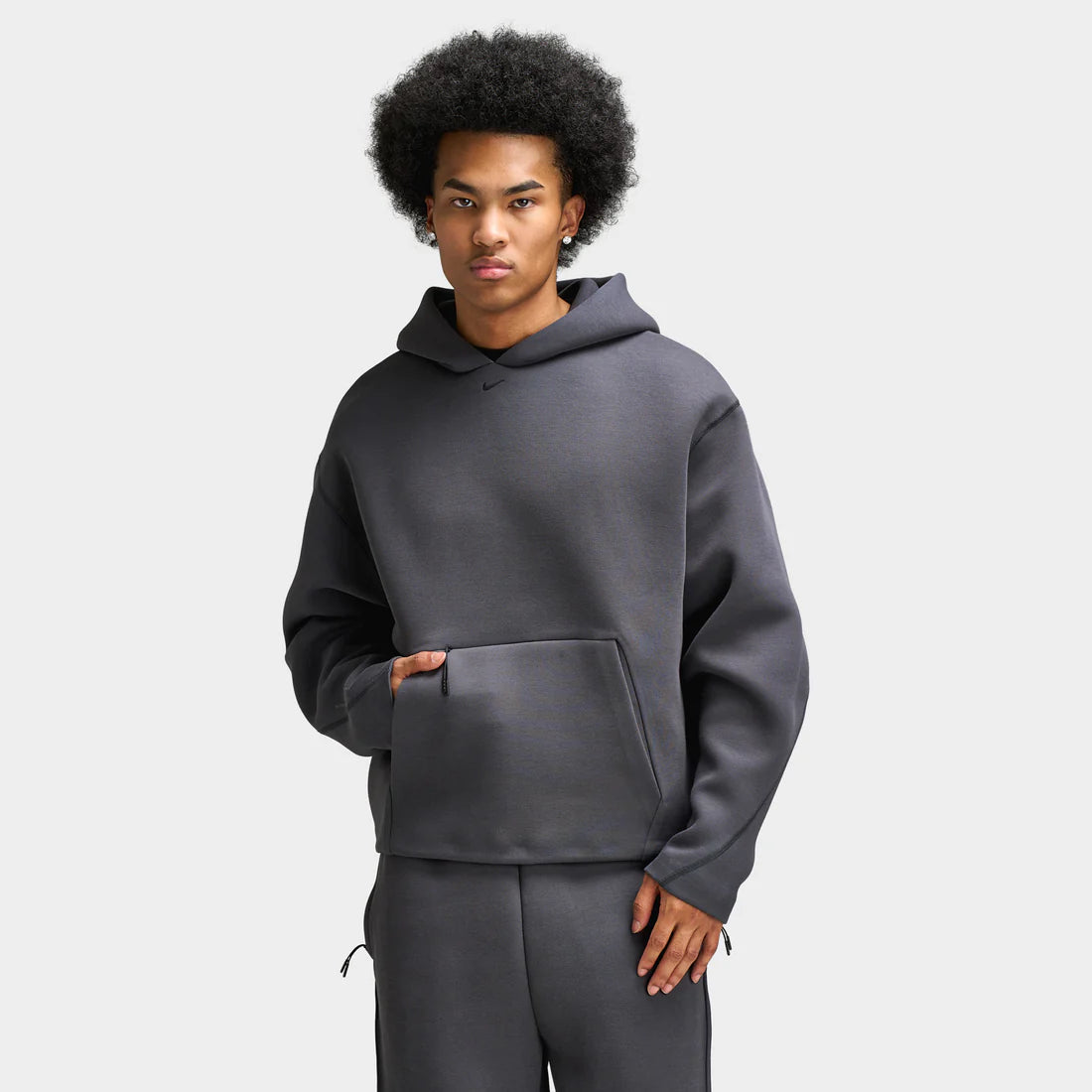 Man wears Nike Tech Ergonomic Pullover Hoodie “Anthracite / Black” hoodie. Shop Men’s Clothing now at JD Sports.