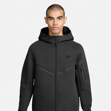 Man wears Nike Tech Fleece Full-Zip Windrunner Hoodie "Black / Black". Shop Men's Clothing now