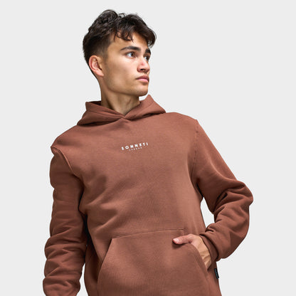 Sonneti London Hoodie 2.0. Three-quarter view of model wearing cocoa brown hoodie with kangaroo pocket and relaxed sleeves.