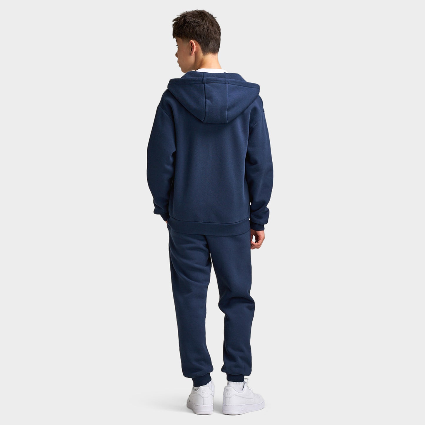 Supply & Demand Juniors' Scape Hoodie. Full-body back view of model wearing washed navy hoodie with raised hood and matching pants.