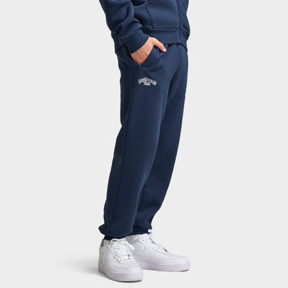 Supply & Demand Juniors' Scape Pants. Three-quarter view of model wearing washed navy pants with elastic cuffs, side pockets and relaxed fit.
