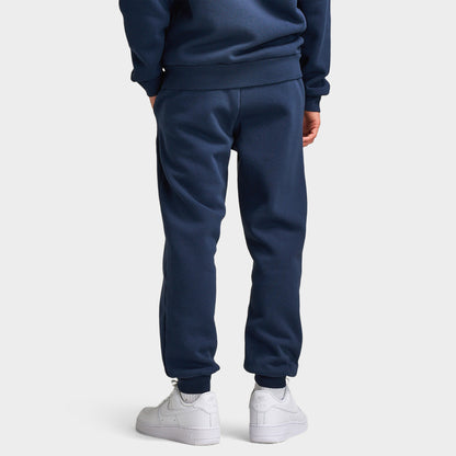 Supply & Demand Juniors' Scape Pants. Back view of model wearing washed navy pants with tapered legs, elastic cuffs and plain rear panels.