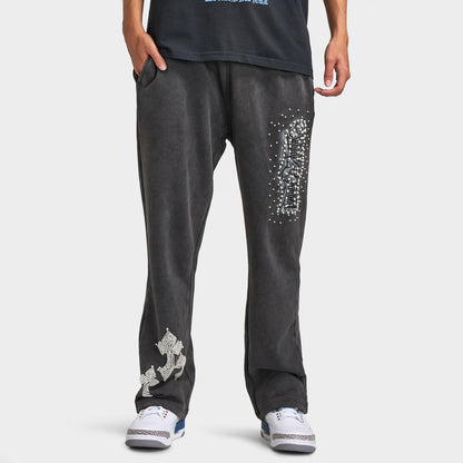 Supply & Demand Murphy Oversized Pants. Front view of model wearing black oversized pants with wide legs, washed finish and large white graphic details.