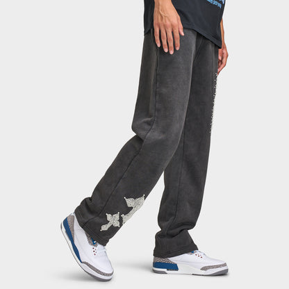 Supply & Demand Murphy Oversized Pants. Three-quarter view of model wearing black oversized pants with wide legs, washed finish and graphic details.