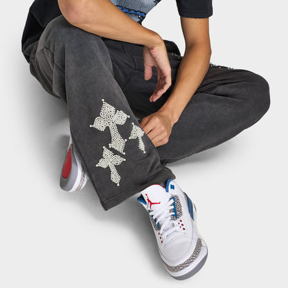 Supply & Demand Murphy Oversized Pants. Close-up of black oversized pants showing lower-leg graphics and wide hem over sneakers.