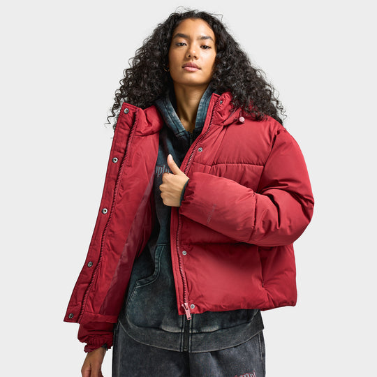 Supply & Demand Women's Macy Jacket. Front view of model wearing pomegranate puffer jacket with high collar, front zip closure and relaxed fit.