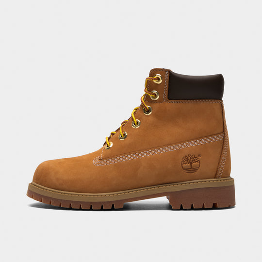 Timberland Juniors' 6" Premium Lace Up Waterproof Boot. Side view of wheat junior boot with padded black collar, yellow laces, Timberland tree logo and lugged sole.