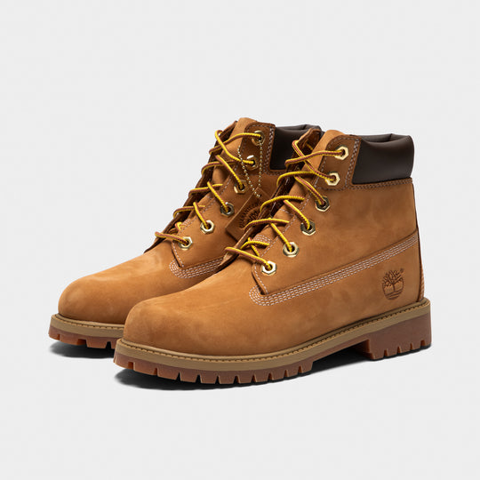 Timberland Juniors' 6" Premium Lace Up Waterproof Boot. Three-quarter view of wheat junior boots with yellow laces, padded black collars and lugged soles.