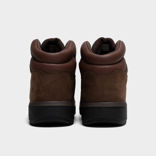 Timberland Field Boot. Rear view of a pair of mid-top boots displaying dark brown nubuck heel counters, padded brown leather collars, tonal stitching details, and heavy-duty black lugged rubber soles. 