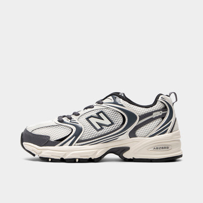 New Balance 530. Side view of sea salt and magnet sneaker with layered mesh panels, dark N logo and sculpted sole.