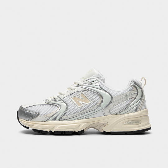 New Balance 530. Side view of silver metallic and linen sneaker with layered mesh panels, metallic N logo and sculpted cushioned sole.
