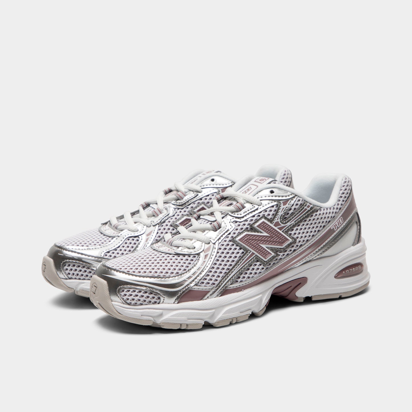 New Balance 740. Three-quarter view of silver metallic, raincloud and pebble sneakers with grey laces, layered overlays and pink N branding.