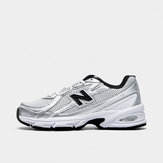 New Balance 740. Side view of white, silver metallic and black sneaker with layered mesh panels, black N logo and sculpted sole.