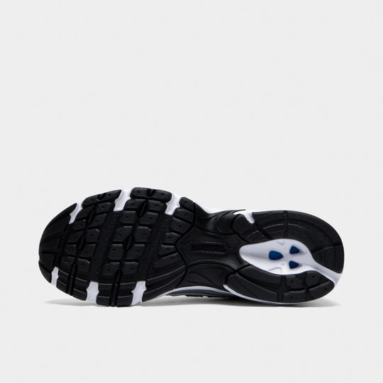 New Balance 740. Bottom view of white, silver metallic and black sneaker showing segmented black and white outsole with circular heel detail.
