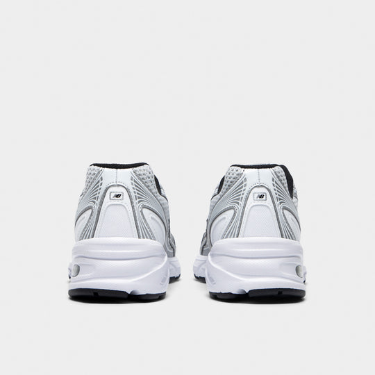 New Balance 740. Rear view of white, silver metallic and black sneakers with silver heel panels, black accents and white midsoles.