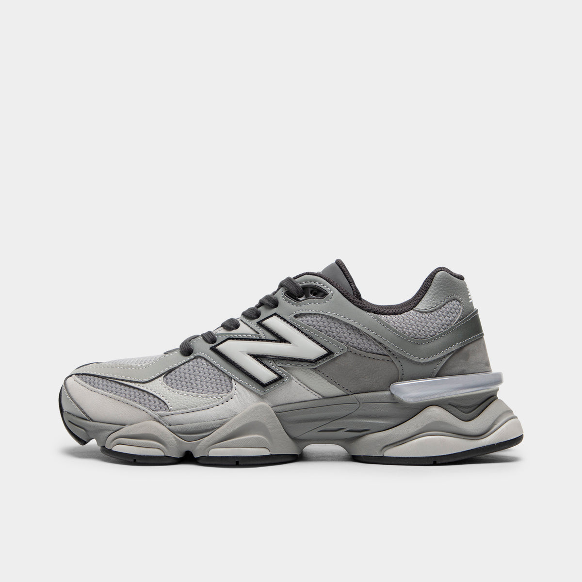New Balance 9060. Side view of chunky lifestyle sneakers featuring a harbor grey mesh upper with slate grey pigskin suede overlays, silver "N" logo with black outline on the midfoot, dark grey laces, translucent CR device at the heel, sculpted dual-density ABZORB and SBS cushioned midsole, and a black rubber outsole. 