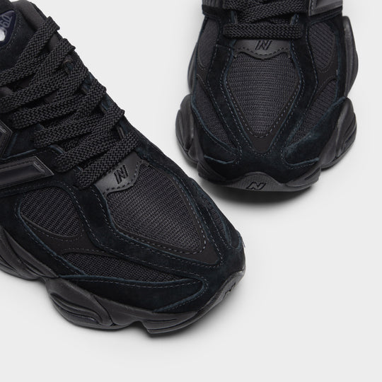 New Balance 9060. Close-up of black and phantom sneaker showing black laces, mesh upper, layered panels and N logo.