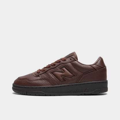 New Balance 950. Side view of low-top sneakers featuring a dark brown tumble leather upper, matching dark brown leather "N" logo on the midfoot with black outline stitching, dark brown laces, brown padded collar, black rubber cupsole, and a black rubber outsole. 